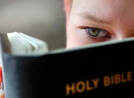 Child reading a Bible.