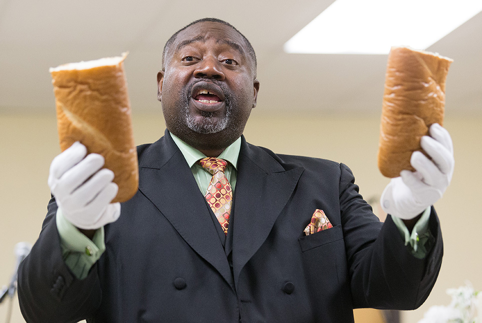 The Rev. Mark Windley blesses communion bread at Amazing Grace Community of Faith in Louisville, Kentucky. Photo by Mike DuBose, United Methodist Communications.