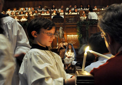 An acolyte lights a candle during a special service at St. Paul's United Methodist Church. Children flll all the roles for the service on the third Sunday of Advent.