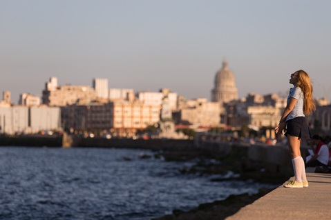 Una estudiente se detiene a cantar desde lo alto del malecón en La Habana. Foto cortesía de Mike DuBose.