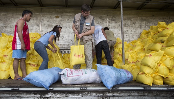 The Rev. Jack Amick (center) and Ciony Ayo-Eduarte (to Amick's left) join volunteers to load a truck at the offices of the United Methodist Committee on Relief in Manila with relief supplies for survivors of Typhoon Haiyan in the Philippines. Amick heads the relief agency's international disaster response and Ayo-Eduarte is UMCOR's manager for the Philippines. Photo by Mike DuBose, UMNS.