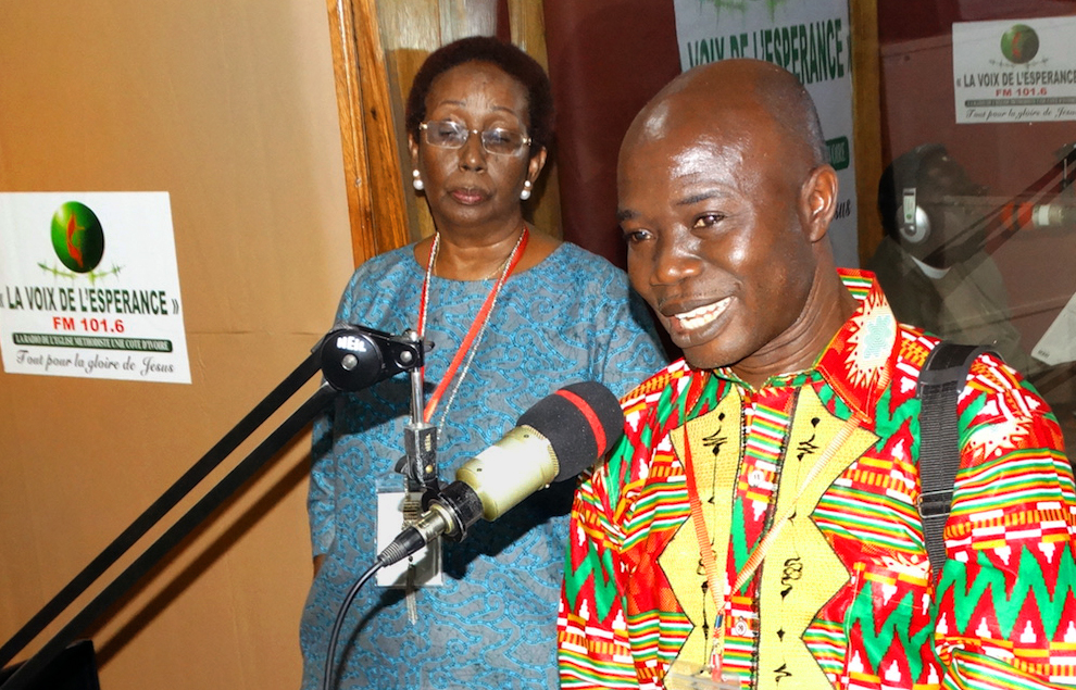 Edward Lahai Massaquoi from Liberia shares his joy about having the support of a United Methodist Radio Network for the United Methodist radio station in Liberia during a live interview at Radio La Voix De l’esperance in Abidjan, Côte D’Ivoire. Lydie Acquah, coordinator for the network, listens to Massaquoi. Photo by Phileas Jusu, UMNS.