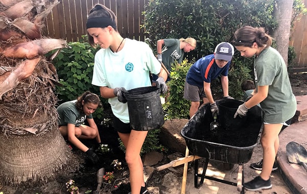 Students planting with wheel barrow 
