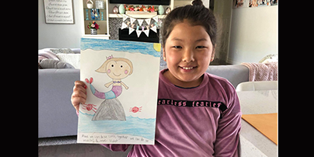 Violet, an Illinois third-grader and a member of Grace UMC in Carbondale, holds up her drawing.