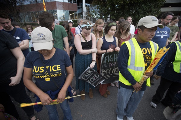 Membros e apoiadores da Coalition of Immokalee (Fla.) Workers (Coalizão de Trabalhadores de Immokalee) oram em Nashville, Tennessee, na conclusão de um protesto contra a recusa da rede de supermercados Publix em aderir a um programa trabalhista de direitos dos trabalhadores agrícolas. O Livro de Resoluções da Igreja Metodista Unida exige que os empregadores "tratem os trabalhadores agrícolas e suas famílias com dignidade e respeito". Foto por Mike DuBose, Notícias MU.