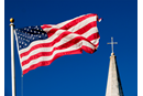 An American flag and church steeple viewed against very clear blue sky. Photo by imdm, iStockphoto.com.