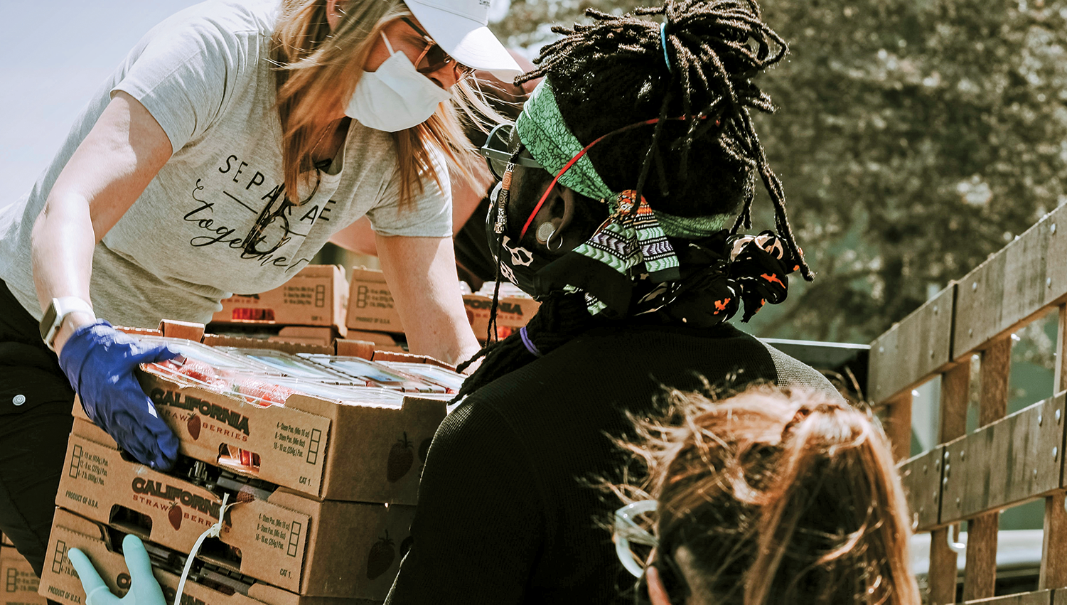 Masked volunteers preparing to serve food to the community. Photo by Joel Muniz. 
