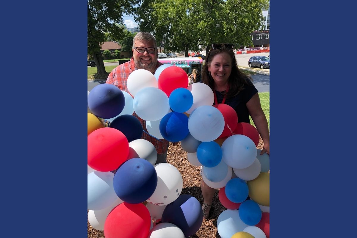 Joe Iovino and Jennifer Rodia took advantage of the festive balloon displays to grab a photo together at the UMCom picnic. (Photo provided by Jennifer Rodia.)