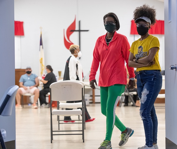 The Rev. Dr. Stephanie Moore Hand (left) and her daughter Ashlee Hand monitor the line of people waiting to receive a COVID-19 vaccination during a clinic at St. Mark’s United Methodist Church in Charlotte, N.C. (Photo by Mike DuBose, UM News.)