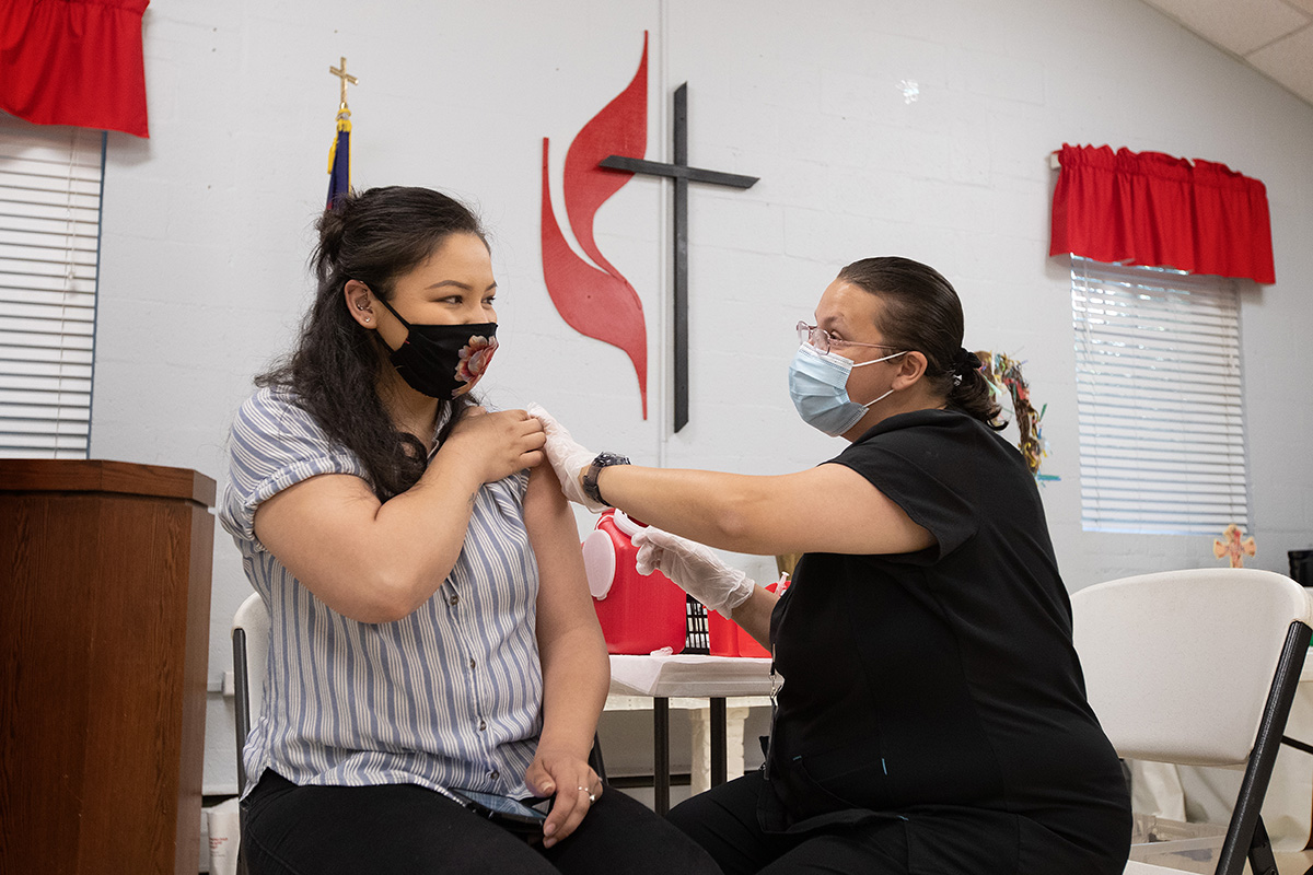 Ana Salazar (left) receives a COVID-19 vaccination from registered nurse Tabitha England during a clinic at St. Mark’s United Methodist Church in Charlotte, N.C., in April. The Rev. Dana Horrell, pastor at Cooperstown (N.Y.) United Methodist Church, has written a handbook to help congregations reach out to the unvaccinated. File photo by Mike DuBose, UM News.