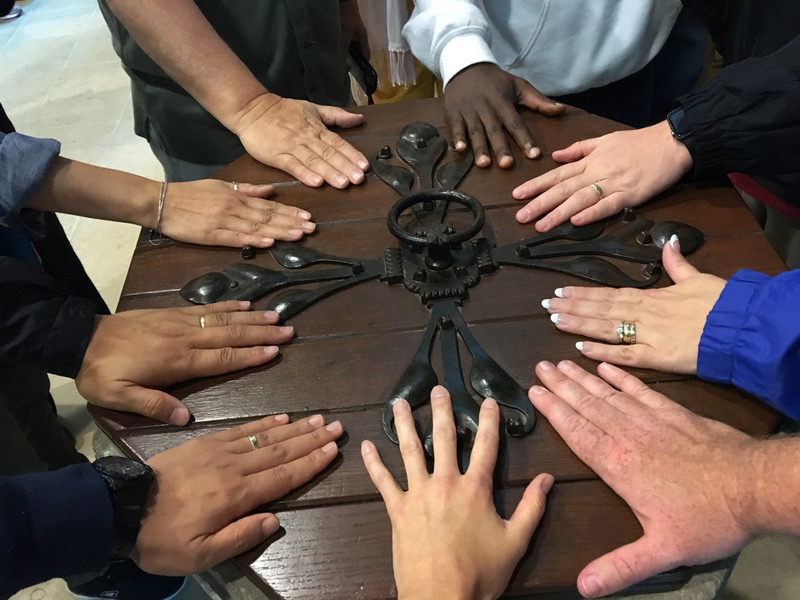 Members of the 2016 Wesley Pilgrimage in England rest their hands on the Baptismal font at St. Andrew's church in Epworth where John Wesley was baptized. Photo by the Rev. Anita Mays.