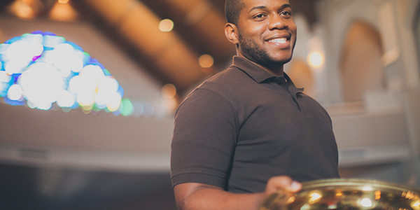 Smiling young adult holding an offering plate. Stock Photo. LeadingIdeas Smiling young adult holding an offering plate. Stock Photo. LeadingIdeas