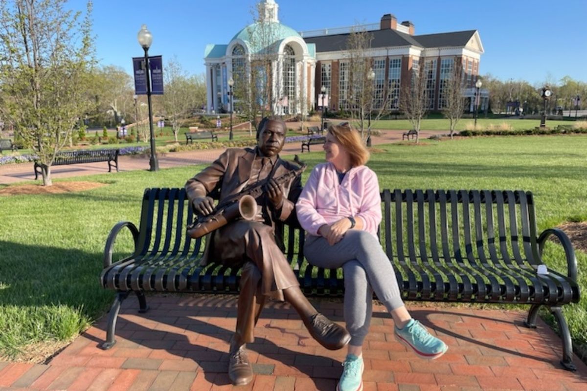 Two High Point natives sitting on a bench: John Coltrane, iconic jazz saxophonist, left; Crystal Caviness, fearless champion of stories for The UMC at United Methodist Communications, right.