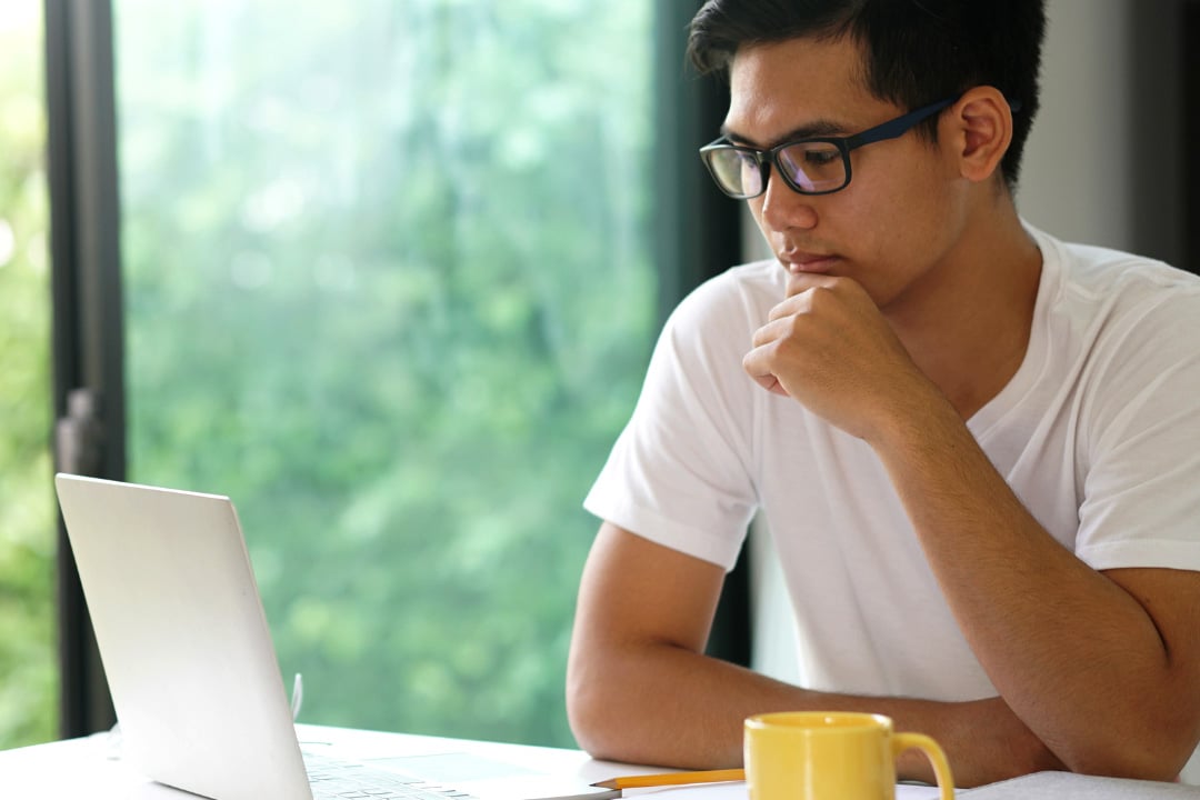 Find a United Methodist-affiliated college or University. Image of young Asian man working on a  computer. Image courtesy of the General Board of Higher Education and Ministry.