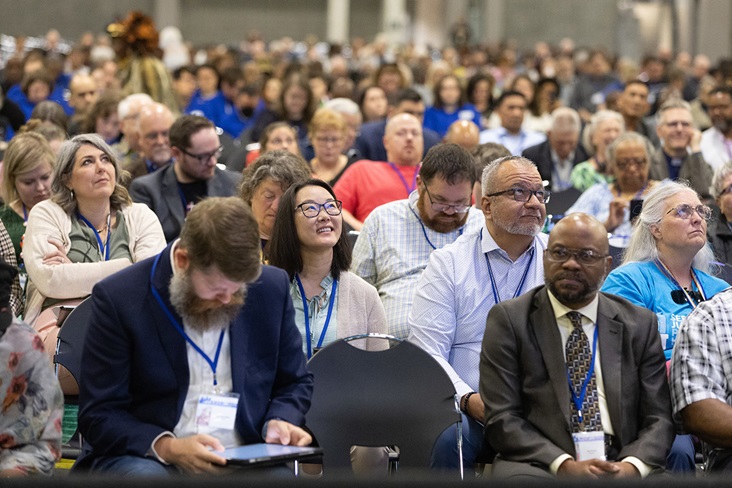 Visitors to the United Methodist General Conference in Charlotte, N.C., watch the proceedings on overhead video monitors. Photo by Mike DuBose, UM News.