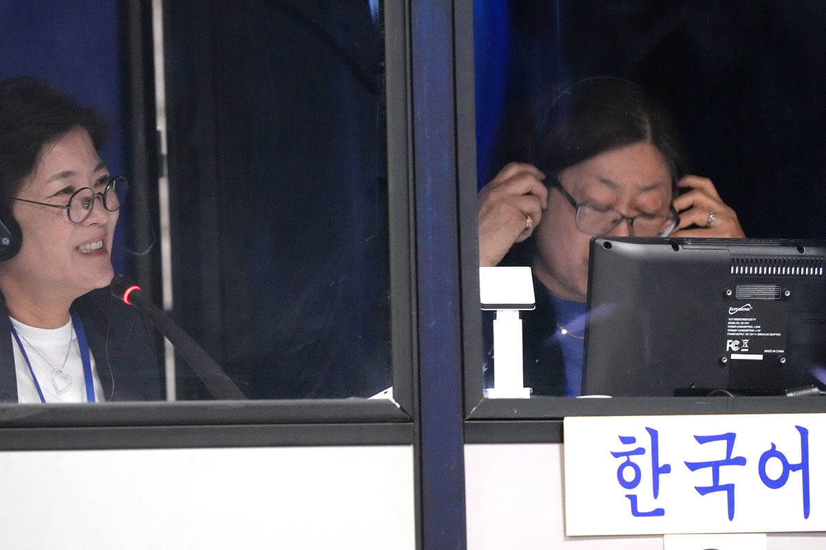 Hannah Ka y Chan Gillham interpretan la conferencia al coreano durante la Conferencia General Metodista Unida reunida en Charlotte, Carolina del Norte, el 29 de abril. Foto de Larry McCormack, Noticias MU.