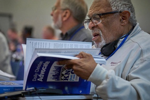 General Conference 2024 delegate reviewing Daily Christian Advocate Ivan James, a lay delegate from the Missouri Conference, reviews the collection of legislation that he and other committee members are considering in the first days of the 2024 United Methodist General Conference in Charlotte, N.C. Photo by Paul Jeffrey, UM News.