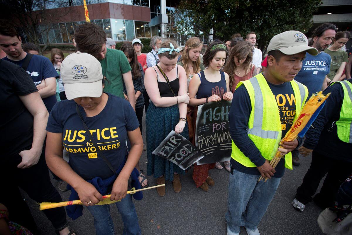 Members and supporters of the Coalition of Immokalee (Fla.) Workers pray in Nashville, Tenn., at the conclusion of a protest against the Publix supermarket chain's refusal to join a farm workers' rights labor program. "The Book of Resolutions of the United Methodist Church" demands that employers "treat farm workers and their families with dignity and respect; and that corporate processors, food retailers, and restaurants take responsibility in proportion to the power they possess for the treatment of the farm workers in their supply chains." Photo by Mike DuBose, UMNS