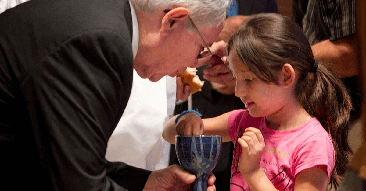 한 어린이가 MARCHA에서 성찬식에 참여하고 있다.