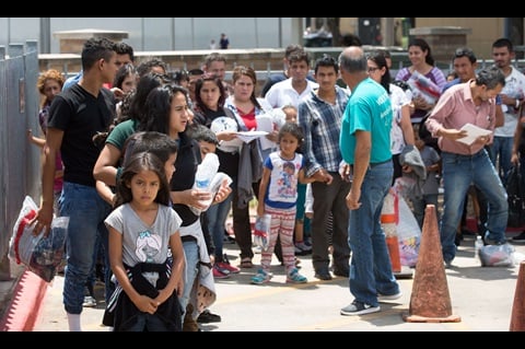 Immigrants who have been released from detention by the U.S. Border Patrol line up outside the bus station in McAllen, Texas. Photo by Mike DuBose, UMNS.