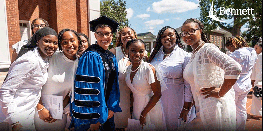 Photo credit: (center Suzanne Walsh, president of Bennett College poses with students.) Screen grab from Bennett College website video