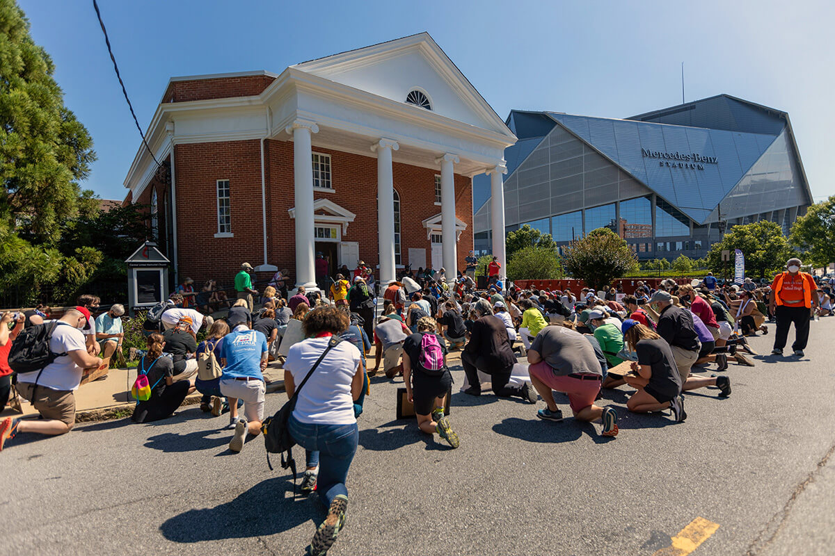 People kneel in front of Central United Methodist Church in Atlanta during a protest march that followed the 2020 murder of George Floyd by police in Minneapolis. The church was established in 1866 in one of the few areas where freed Black people could settle after the Civil War. It moved in 1928 to this location near Gammon Theological Seminary, on what is now Martin Luther King Jr. Drive. File photo by the Rev. Joseph McBrayer.