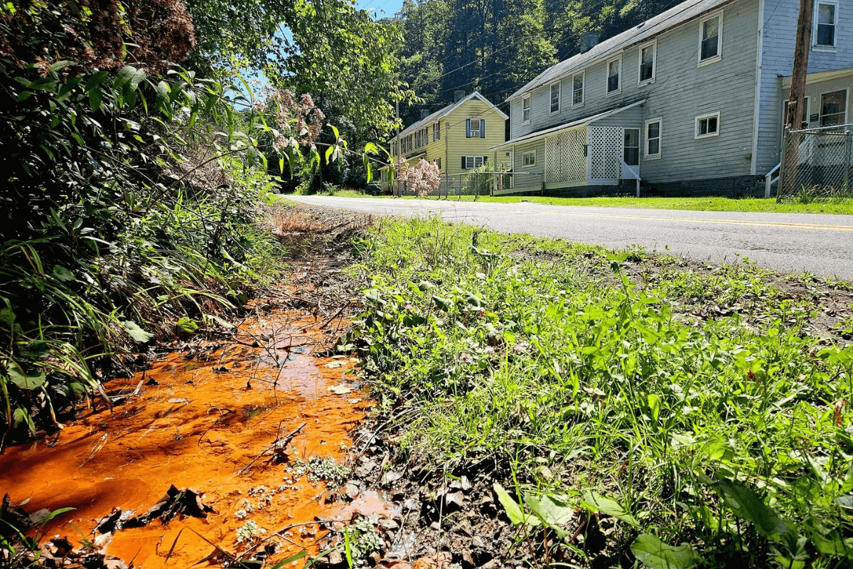 A small stream in Elbert, McDowell County, shows the rusty water that runs through nature and through residential water pipes.  Photo courtesy of West Virginia Faith Collective.