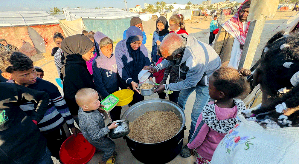 Hana's family arrives at the camp gathering point for a hot, cooked meal. (Photo: IOCC)