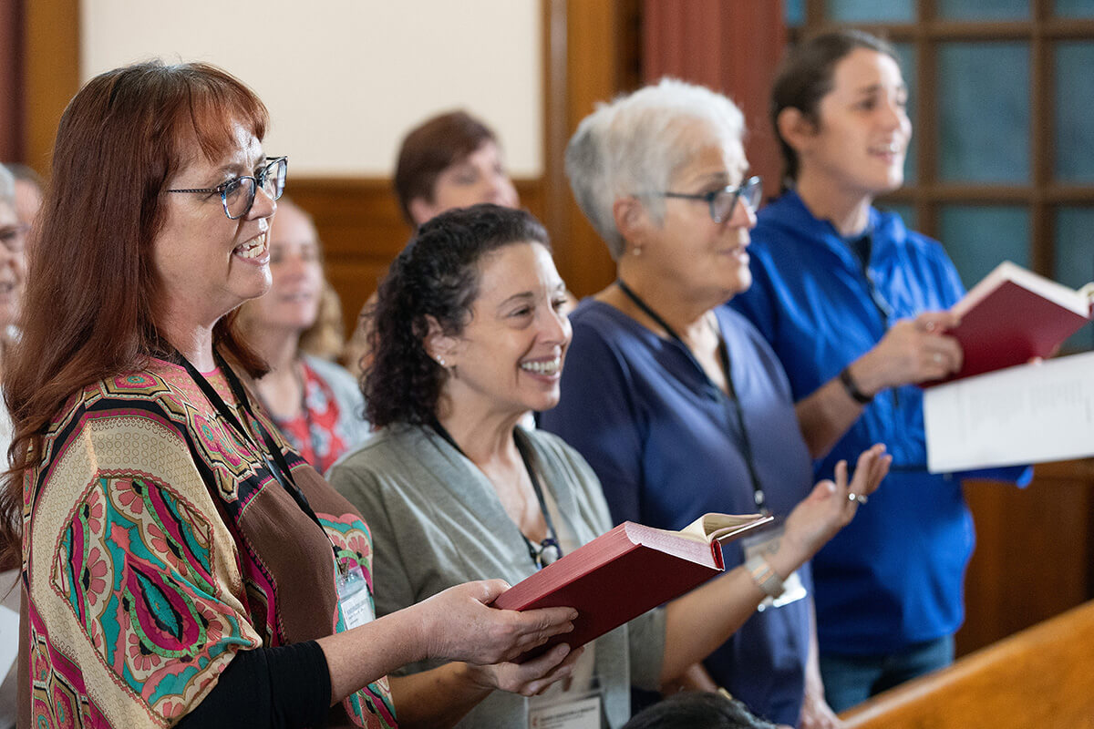 Participants in the 2025 United Methodist Church Deacons Gathering sing during opening worship at the Upper Room Chapel in Nashville, Tenn. From left are the Rev. Shannon Howard, the Rev. Tina Marie Rees, the Rev. Sherry Brady and Candace Brady. A focus of the event was deacons’ new sacramental authority approved at last year’s General Conference. Photo by Mike DuBose, UM News.