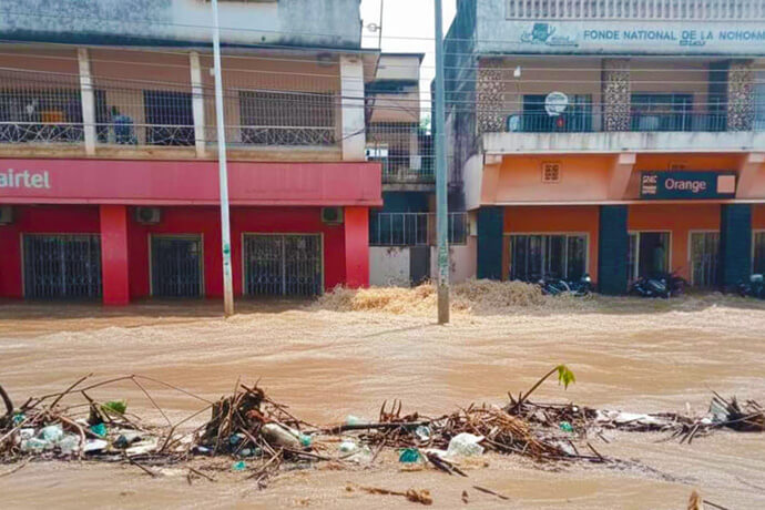 Des bâtiments commerciaux et résidentiels sont entourés d'eaux de crue boueuses, et des débris flottent au premier plan dans la capitale de Tanganyika. Les pluies torrentielles qui ont ravagé Kalemie en octobre ont submergé des quartiers entiers, rendant les routes impraticables et affectant environ 3 000 personnes, y compris des Méthodistes Unis. Photo avec l’aimable autorisation du Bureau de Gestion des Catastrophes de la Région Épiscopale du Tanganyika.