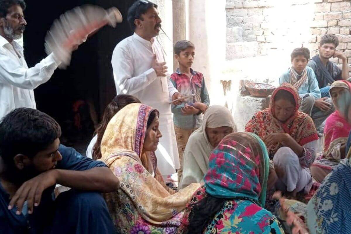 Insar Gohar, a National in Mission worker in Pakistan, meets with families in one of their homes to listen to their concerns as they process their grief. Photo courtesy of Insar Gohar.