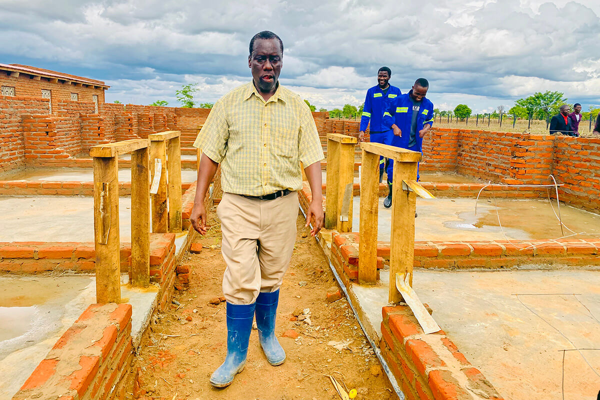 Kephus Mtambo, farm project coordinator for Mikundi Dairy Farm in Blantyre, Malawi, walks in a barn that is under construction. The farm is being transformed from a previously neglected irrigation facility into a modern livestock center with support from the Yambasu Agriculture Initiative, a United Methodist Board of Global Ministries program. Photo by Francis Nkhoma, UM News. 