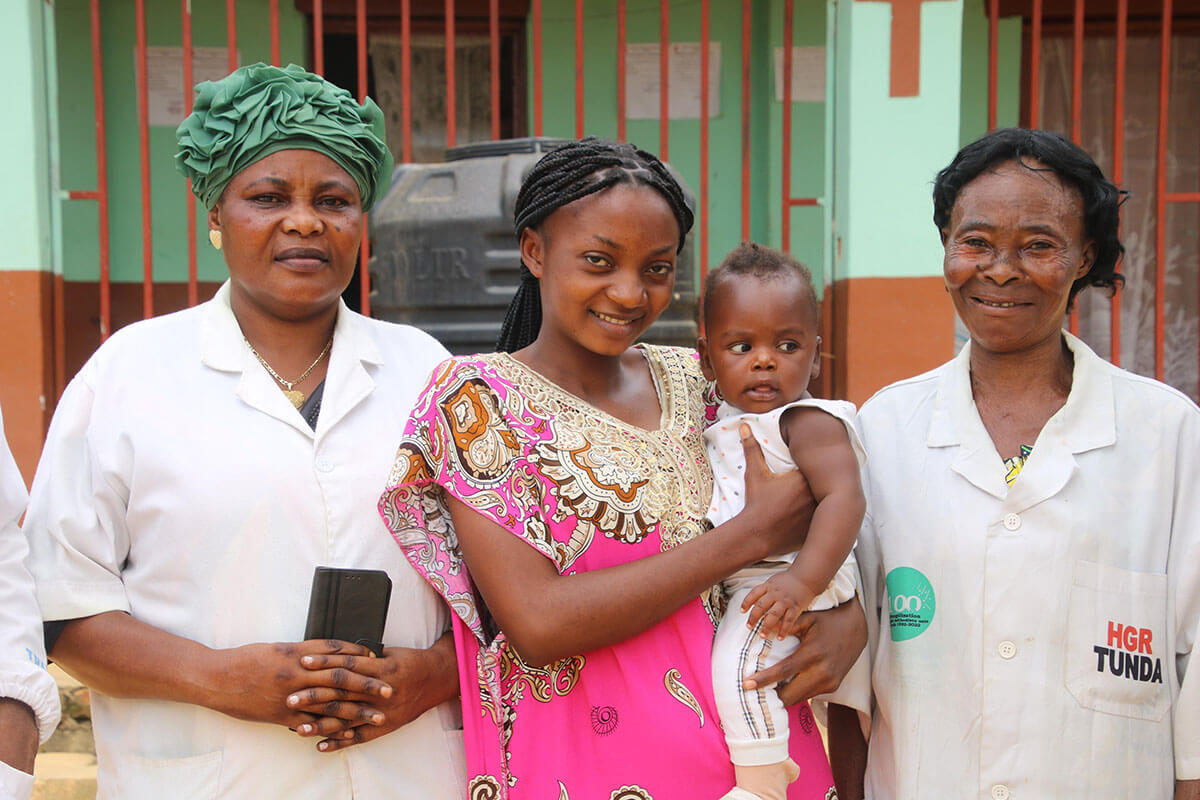Marie Otshumba, l'une des bénéficiaires du programme de santé maternelle, porte fièrement son fils Amisi, âgé de quatre mois, aux côtés des infirmières du Centre Hospitalier Méthodiste Lokole à Kindu. Après cinq ans de fausses couches à répétition, Marie témoigne de la transformation de sa douleur en joie grâce au suivi prénatal. Photo de Chadrack Tambwe Londe, UM News.