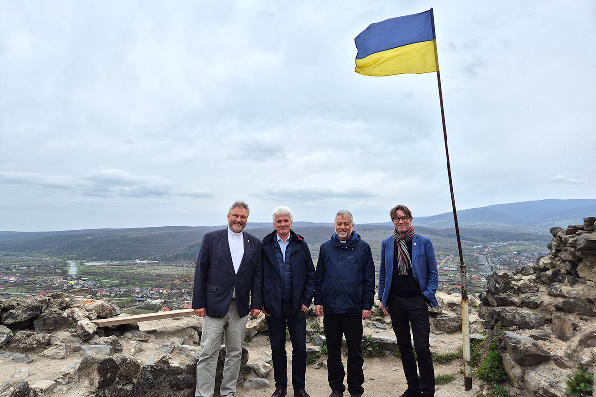 (From left) Bishop Werner Philipp, local preacher István Pásztor from Hungary, Bishop Stefan Zürcher and Bishop Knut Refsdal stand under a Ukrainian flag at Nevytske Castle, north of Uzhhorod, during their visit to Ukraine on March 26-30. The bishops’ trip was intended as a sign of solidarity and a reminder to people in Ukraine that they have not been forgotten. Photo courtesy of EmK-Öffentlichkeitsarbeit Germany, UM News.