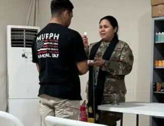 Chaplain (Major) Amor Del Rosario serves communion to a soldier. Photo courtesy of Rev. Amor Del Rosario.