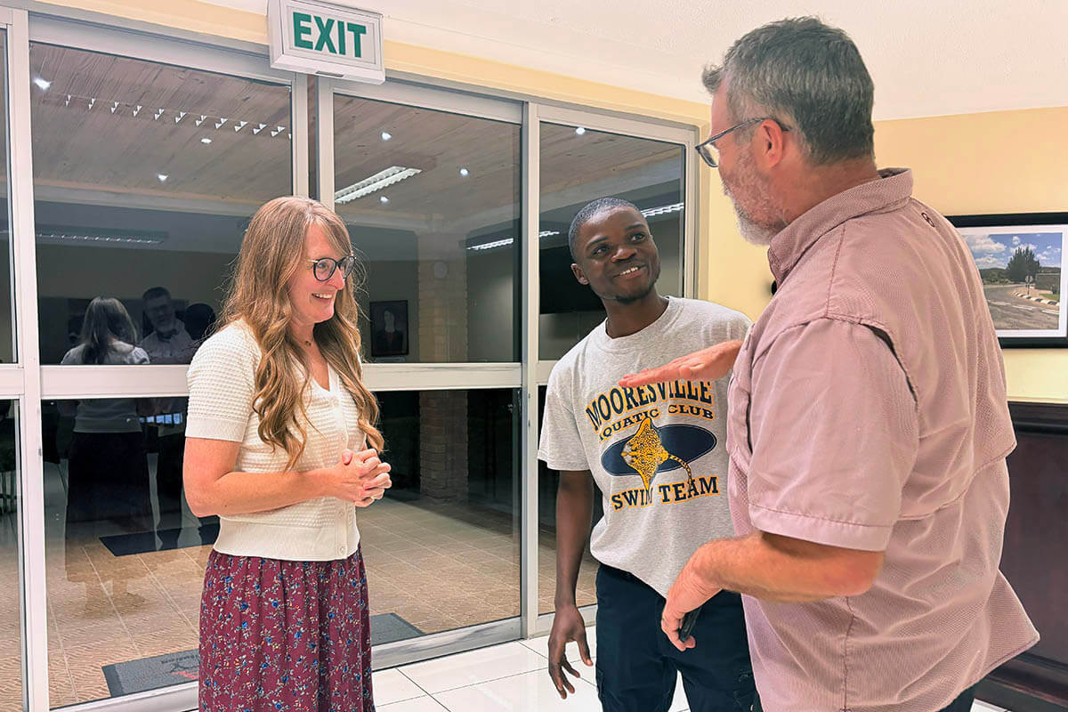 Mykal Jones (right) recalls how short Isaac Sakala (center) was when he and wife Traci Jones (left) last saw him 10 years before. The Joneses, who are from Dallas, Texas, supported Sakala’s education from primary school through his graduation at Africa University in Zimbabwe on June 6. Sakala is a beneficiary of the Excel Beyond program run by Family Legacy, a Zambian organization caring for orphans and disadvantaged children and youth. Photo by Eveline Chikwanah, UM News