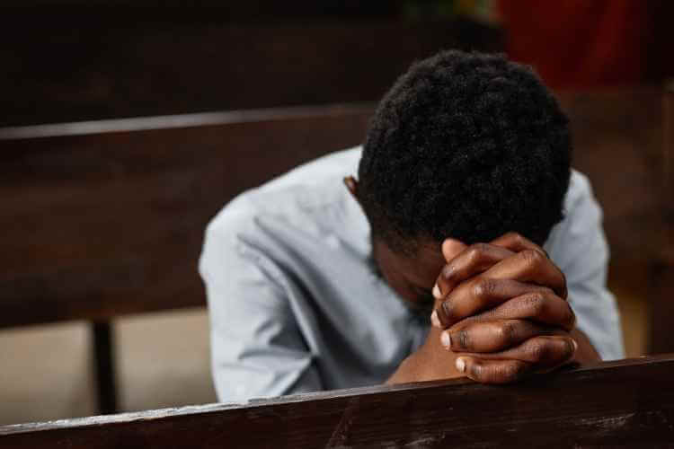 Boy praying. Image courtesy of Canva