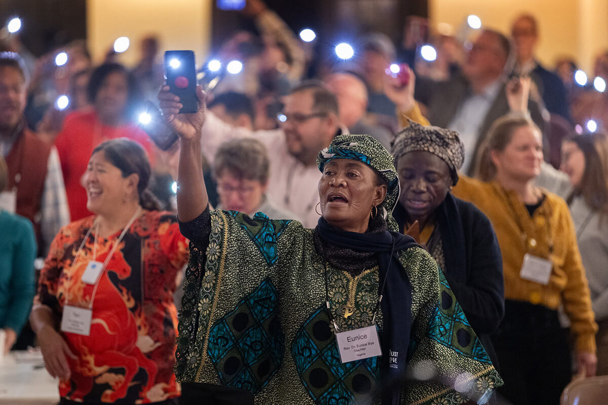 The Rev. Eunice Iliya (center) joins with hundreds of others attending the United Methodist Leadership Gathering in waving their glowing cell phones to the tune of “This Little Light of Mine,” at the close of morning worship on Oct. 23 in the sanctuary of Knox United Church in Calgary, Canada, which is hosting the global event. Photo by Mike DuBose, UM News.